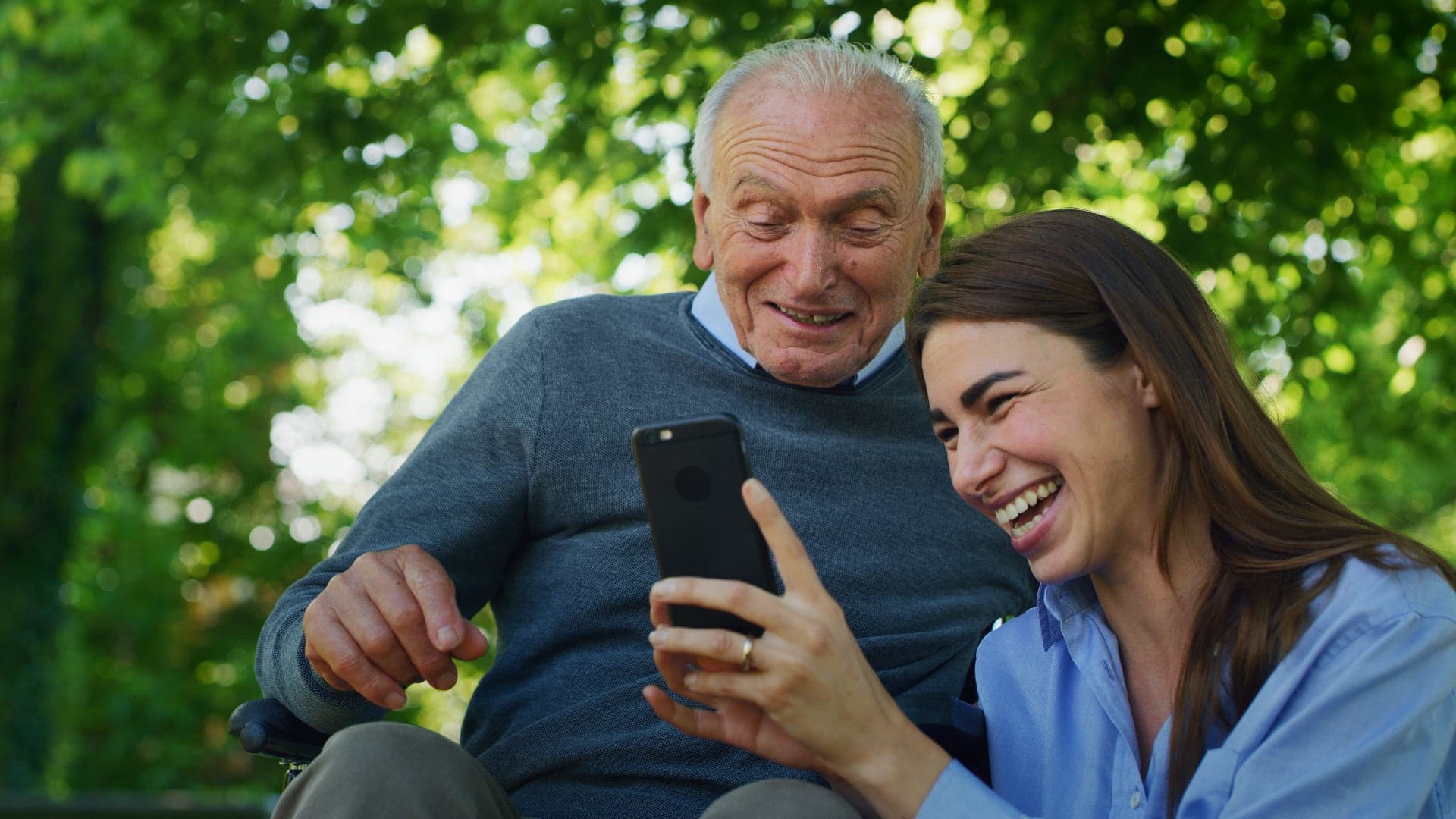 Elderly man and young woman laughing together