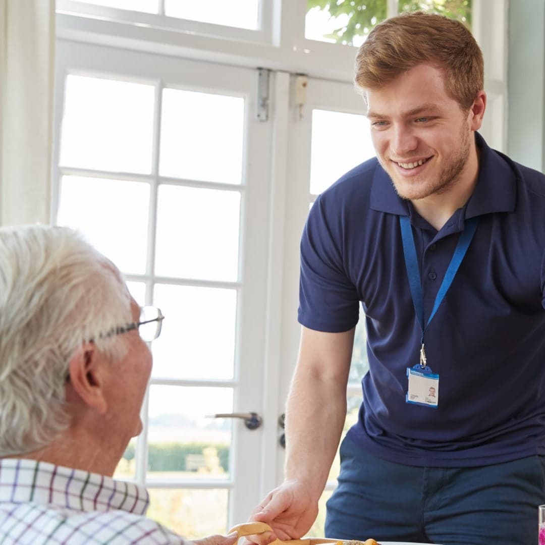 Student caregiver helping a senior — Olera MedJobs